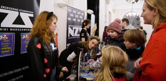 Na zdjęciu ludzie na stanowisku Niezależnego Zrzeszenia Studentów podczas finału Wielkiej Orkiestry Świątecznej Pomocy na Politechnice Warszawskiej