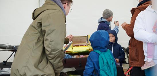 Na zdjęciu ludzie w namiocie Politechniki Warszawskiej na 28. Pikniku Naukowym
