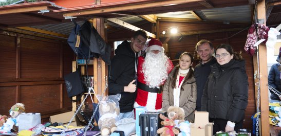 Na zdjęciu grupa osób w kiemaszowym domku 