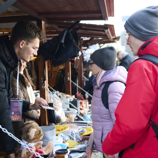 Na zdjęciu ludzie przy domku PW podczas Kiermaszu Świątecznego