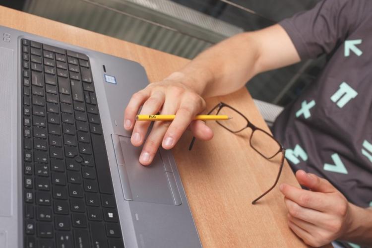 Zdjęcie człowieka pracującego przy laptopie