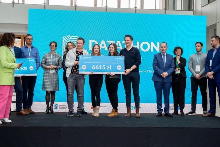 Zdjęcie członków wyróżnionego zespołu odbierającego nagrodę w postaci symbolicznego czeku