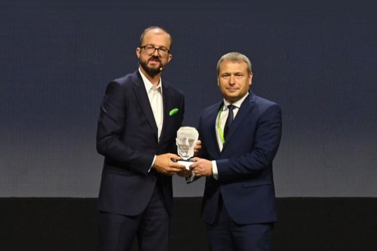 Zdjęcie prof. Adama Woźniaka, Prorektora ds. Rozwoju, odbierającego nagrodę z rąk Piotra Dardzińskiego, Prezesa Sieci Badawczej Łukasiewicz