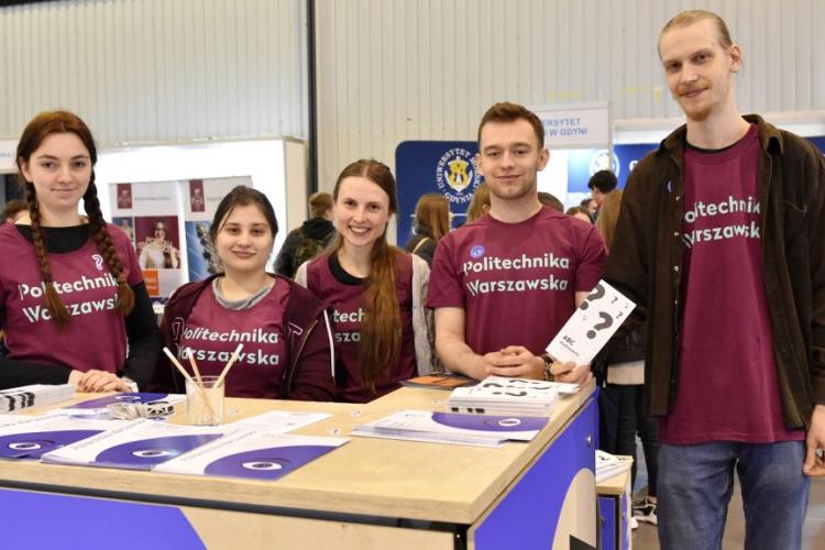 Zdjęcie studentów obsługujących politechniczne stoisko podczas targów