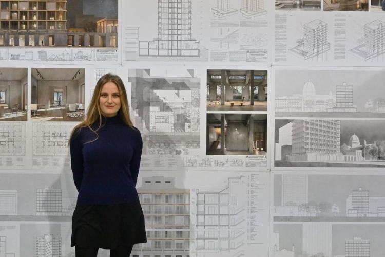 Nadia Sajjad na tle plansz z wizualizacjami pracy dyplomowej