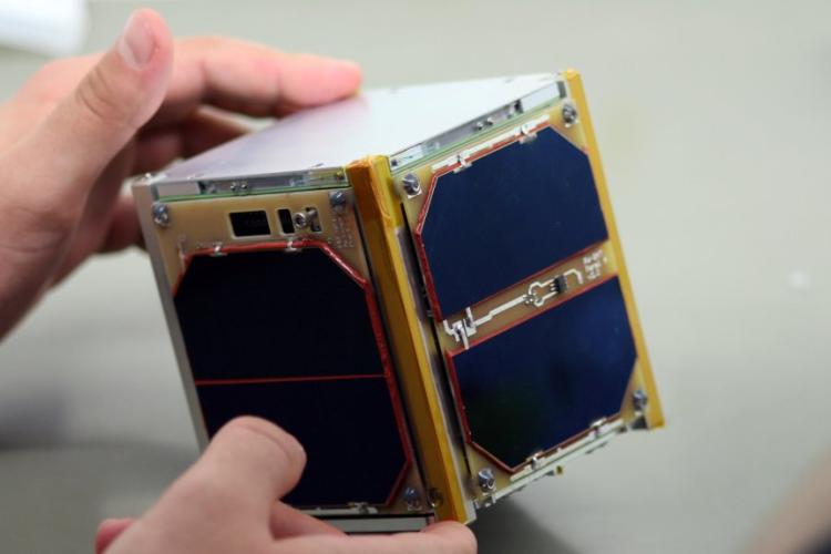 Zdjęcie satelity PW-Sat w rękach jednego z członków zespołu