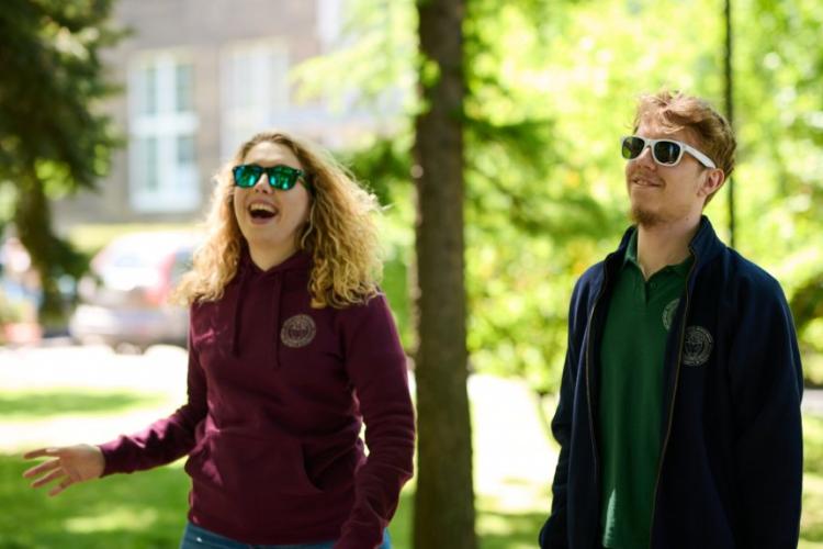 Zdjęcie uśmiechniętych studentów spacerujących po kampusie Politechniki Warszawskiej