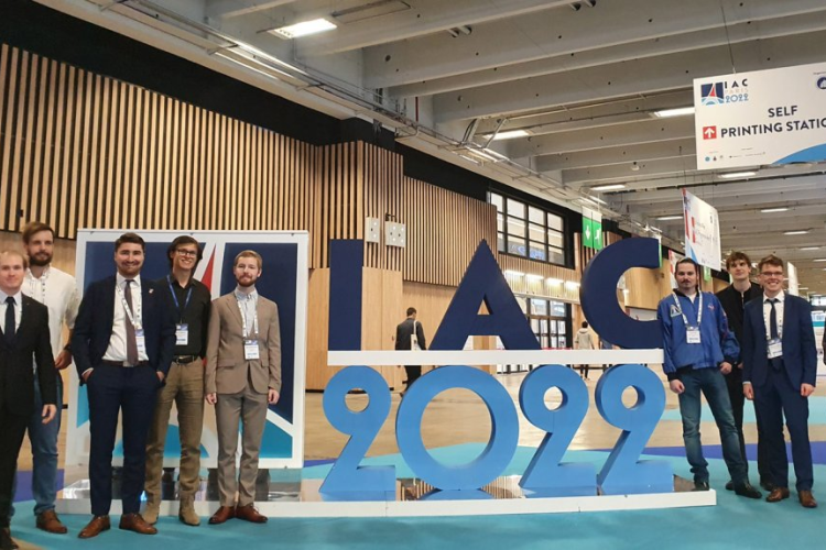 Zdjęcie ludzi z PW stojących przy napisie IAC 2022