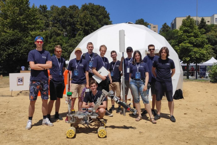 Zdjęcie studentów ze Studenckiego Koła Astronautycznego wraz z łazikiem marsjańskim 