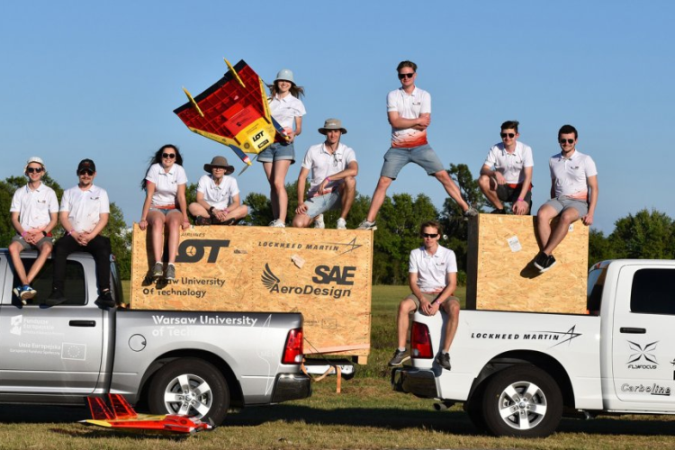 Zdjęcie studentów z koła naukowego SAE AeroDesign z samolotami i skrzyniami do ich przewożenia