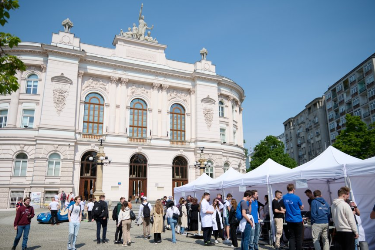 Zdjęcie Gmachu Głównego PW, ustawionych przed nim namiotów i zgromadzonych ludzi