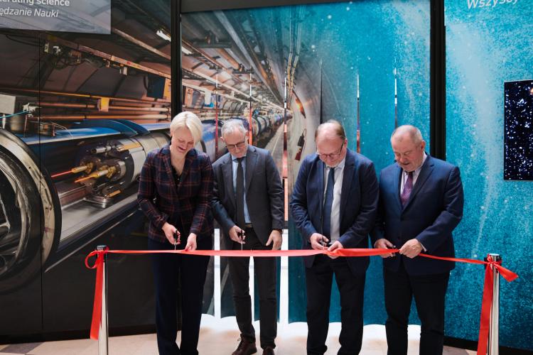 Na zdjęciu cztery osoby przecinające wstęgę - symboliczne otwarcie wystawy „Accelerating Science”