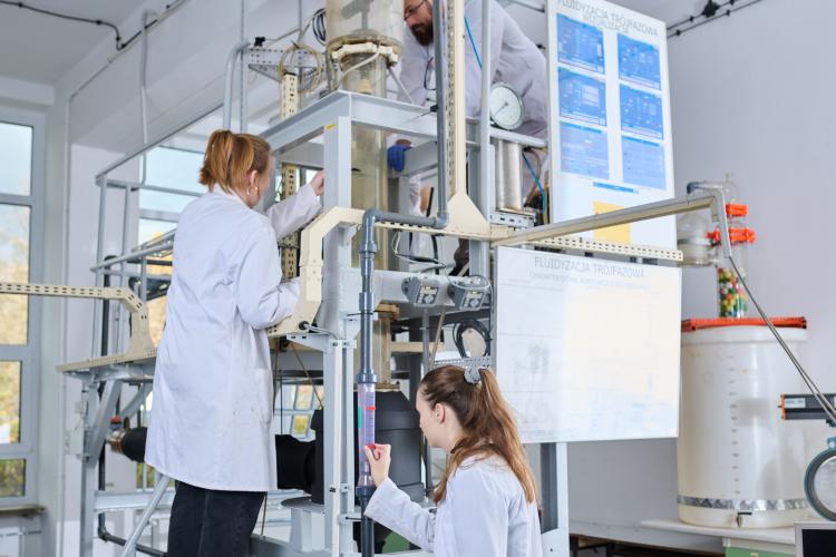 Na zdjęciu trzy osoby przy instalacji do inżynierii chemicznej i procesowej