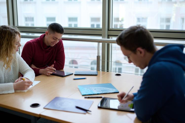 Studentka i studenci uczący się w bibliotece