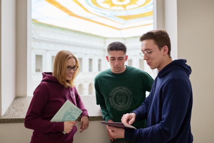 Studentka i studenci rozmawiający w Gmachu Głównym Politechniki Warszawskiej