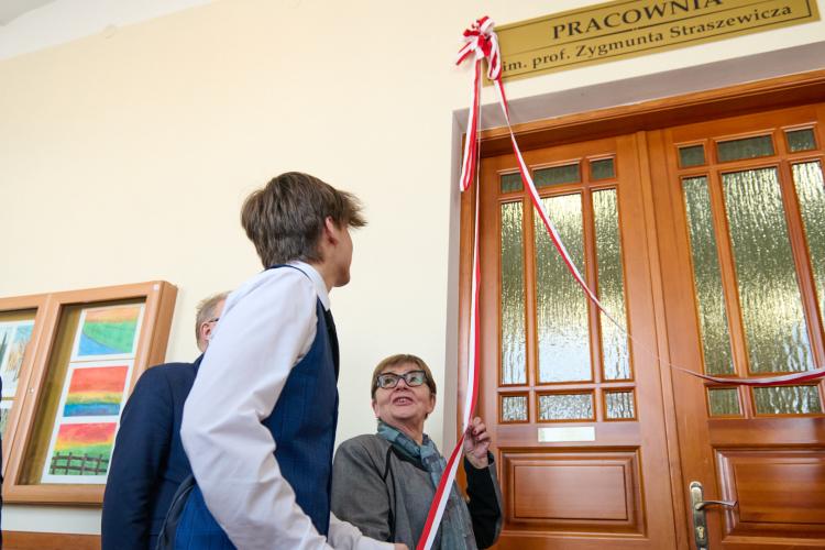 Na zdjęciu kilka osób stojących przy drzwiach i odsłaniających tablicę informującą, że to pracownia im. Zygmunta Straszewicza