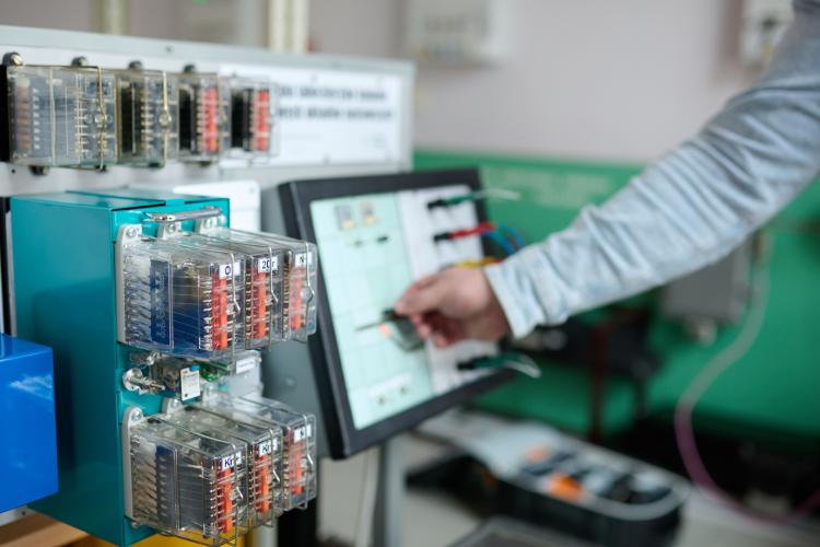 Na zdjęciu ręka, komputer i urządzenia z laboratorium