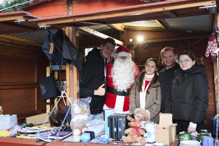 Na zdjęciu grupa osób w kiemaszowym domku 