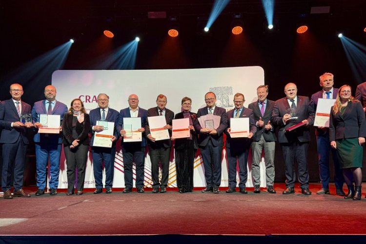 Zdjęcie grupowe wykonane na scenie podczas uroczystości wręczenia nagród Elsevier Research Impact Leaders Awards 2025. Przedstawia kilkanaście osób stojących w rzędzie, część z nich trzyma dyplomy i statuetki.