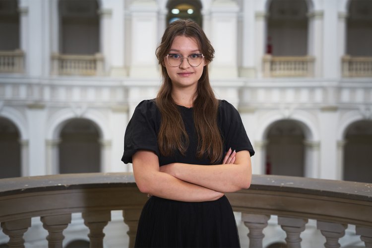 Na zdjęciu: Emilia Bartnik, studentka Wydziału GiK, na tle Dużej Auli PW