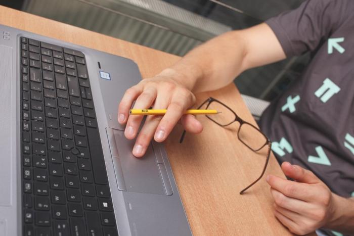 Zdjęcie człowieka pracującego przy laptopie