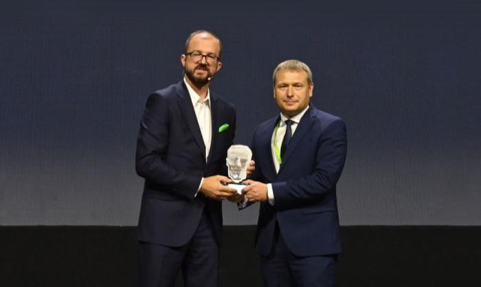 Zdjęcie prof. Adama Woźniaka, Prorektora ds. Rozwoju, odbierającego nagrodę z rąk Piotra Dardzińskiego, Prezesa Sieci Badawczej Łukasiewicz