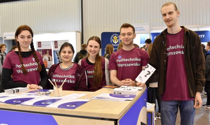 Zdjęcie studentów obsługujących politechniczne stoisko podczas targów