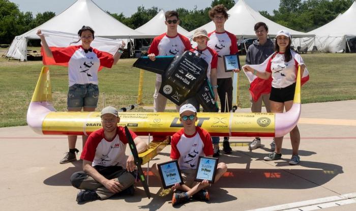 Zdjęcie studentów z SAE AeroDesign z samolotami i nagrodami w zawodach