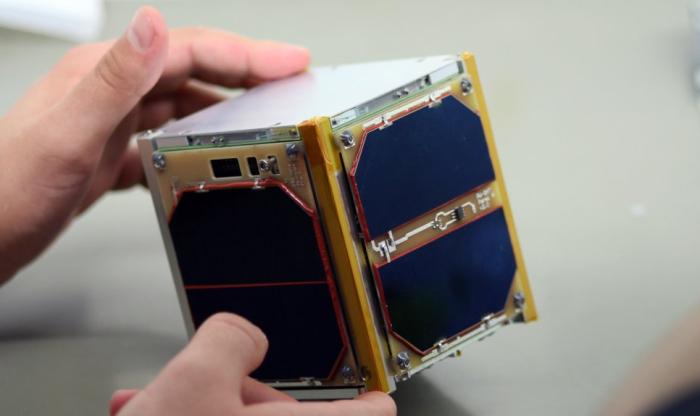 Zdjęcie satelity PW-Sat w rękach jednego z członków zespołu