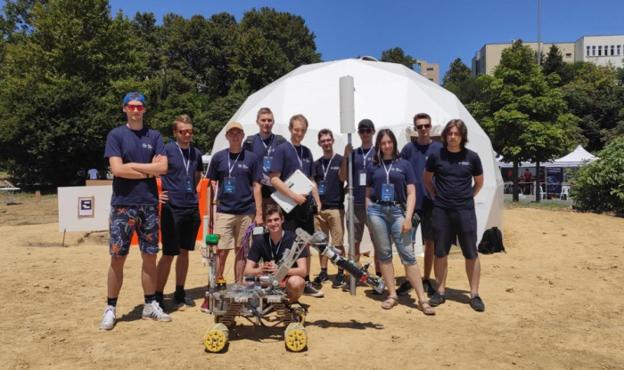 Zdjęcie studentów ze Studenckiego Koła Astronautycznego wraz z łazikiem marsjańskim 