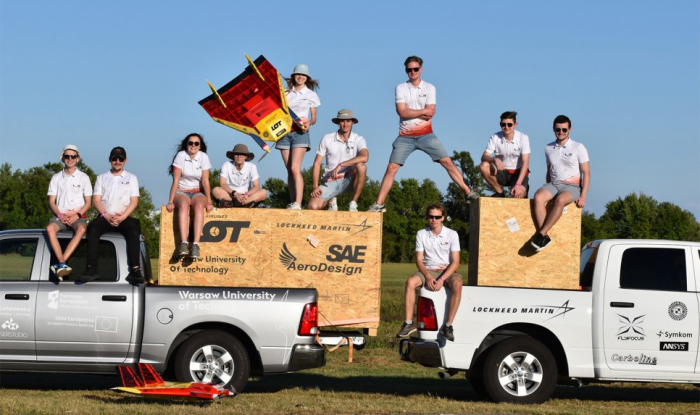 Zdjęcie studentów z koła naukowego SAE AeroDesign z samolotami i skrzyniami do ich przewożenia