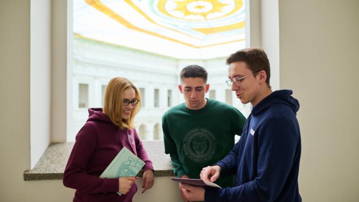 Na zdjęciu troje studentów stojących w Gmachu Głównym PW