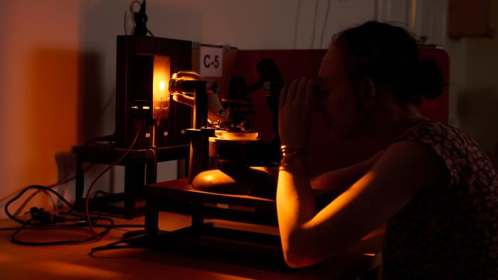 Na zdjęciu osoba przy sprzęcie w laboratorium optycznym 