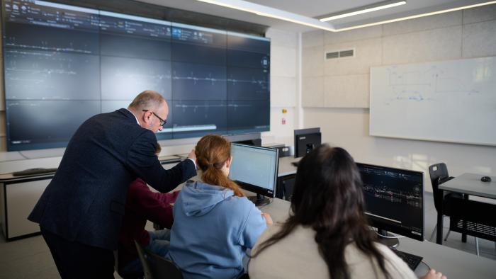 Zajęcia w laboratorium, prowadzący tłumaczy coś studentom