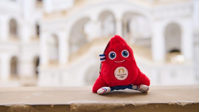 Na zdjęciu maskotka igrzysk olimpijskich w Paryżu - czapka frygijska - na tle Dużej Auli w Gmachu Głównym Politechniki Warszawskiej