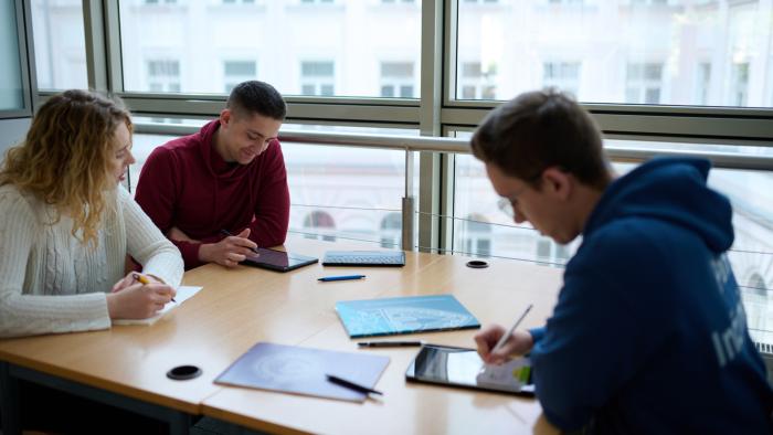 Studentka i studenci uczący się w bibliotece