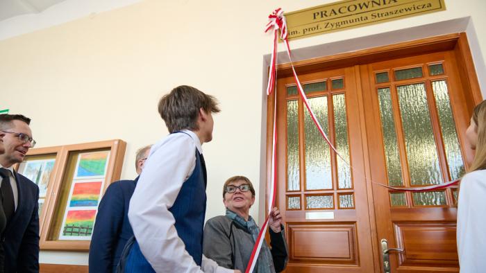 Na zdjęciu kilka osób stojących przy drzwiach i odsłaniających tablicę informującą, że to pracownia im. Zygmunta Straszewicza