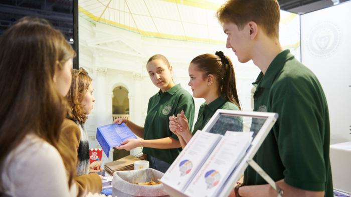 Na zdjęciu grupa osób przy stanowisku Politechniki Warszawskiej na Międzynarodowym Salonie Edukacyjnym 2025