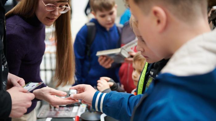Na zdjęciu ludzie przy stanowisku Studenckiego Koła Inżynierii Fotonicznej na Nocy Muzeów