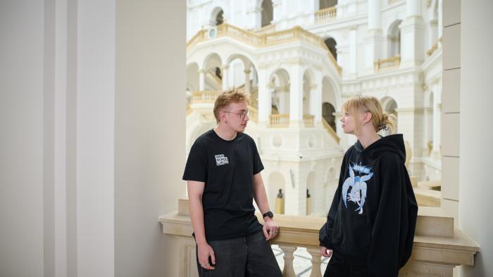 Na zdjęciu student i studentka stoją w Gmachu Głównym PW