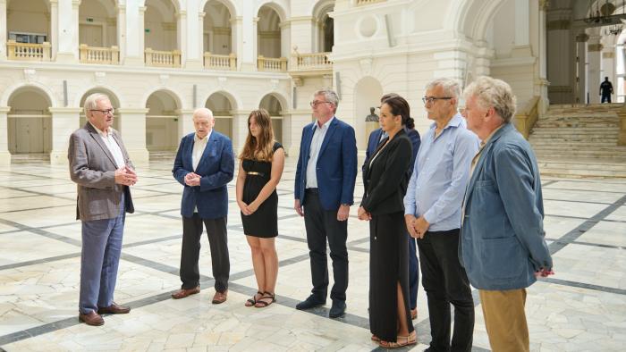 Na zdjęciu osiem osób stoi w Gmachu Głównym Politechniki Warszawskiej