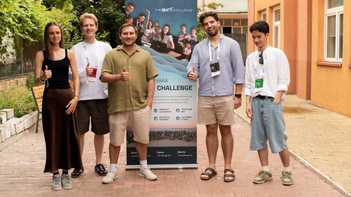 Na zdjęciu pięć osób: reprezentanci Politechniki Warszawskiej stoją na tle roll-upu podczas „The BIM Challenge”