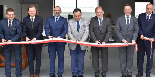 Zdjęcie osób przecinających wstęgę podczas otwarcia laboratorium