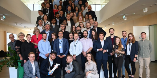 Zdjęcie grupy ludzi stojących na schodach - uczestników i jurorów Tech-Athonu 2023