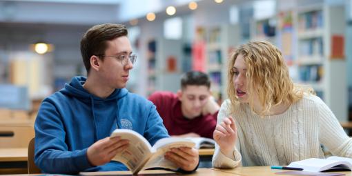 Na zdjęciu troje studentów siedzących w Bibliotece Politechnice Warszawskiej