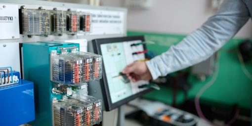 Na zdjęciu ręka, komputer i urządzenia z laboratorium