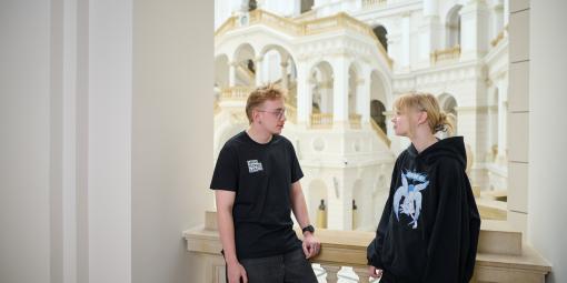 Na zdjęciu student i studentka stoją w Gmachu Głównym PW