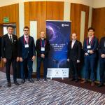 Zdjęcie studentów stojących przy roll-upie