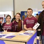 Zdjęcie studentów obsługujących politechniczne stoisko podczas targów