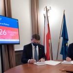 Zdjęcie dwóch osób podpisujących porozumienie